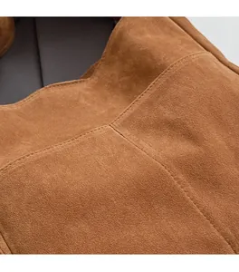 Gros plan détaillé du sac à bandoulière en daim marron montrant les coutures de précision