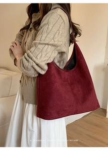 Model wearing a burgundy suede tote bag showing its large capacity and retro vibe