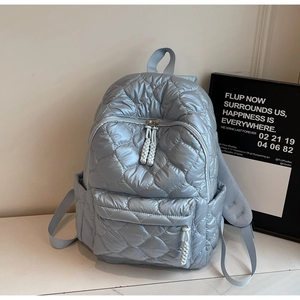 Macro shot of light blue quilted backpack with diamond stitching and side pocket