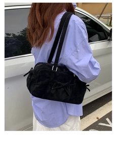 Détail du sac hobo en daim noir avec cordons de serrage à nœuds et fermeture éclair en métal