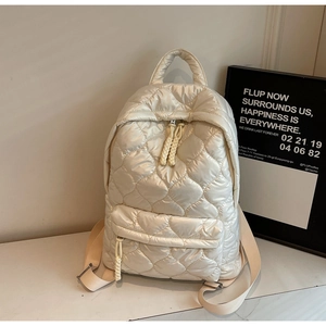 Detail of heart quilted cream backpack with chunky rope zip pull and soft padded texture