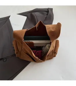 Vue intérieure montrant la grande capacité et le fermoir magnétique du sac seau en daim marron