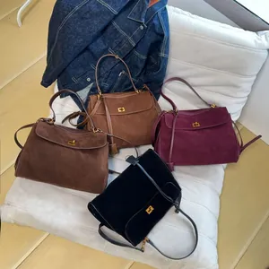 Detail of vintage suede shoulder bags in four colors with gold metal turn-lock closures