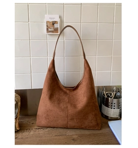 Detail of large brown hobo bag showing the high-quality suede texture and wide shoulder strap