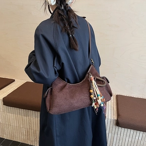 Braune Halbmond-Schultertasche aus Wildleder mit Boho-Quaste am Modell