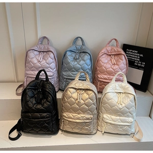 Quilted heart pattern detail on colorful shiny nylon backpacks in six trendy colors