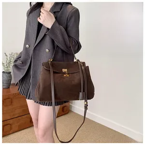 Detail of vintage coffee brown suede tote bag with golden twist lock and leather strap