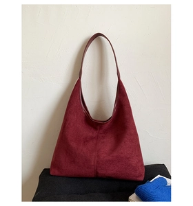 Close-up of wine red matte leather Hobo bag with refined stitching and shoulder strap