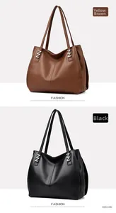 Detail view of large tote bags in tan and black with textured pebbled leather and silver buckles
