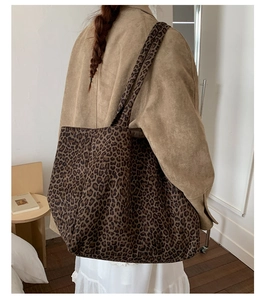 Detailed back view of a large leopard print canvas tote bag worn on shoulder
