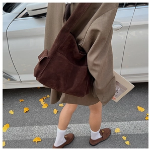 Détail du cabas en daim marron foncé avec poche latérale et design rétro minimaliste