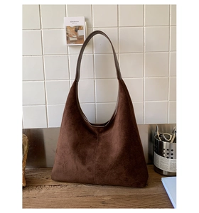 Detail showing the vertical decorative stitching on the brown suede hobo tote bag