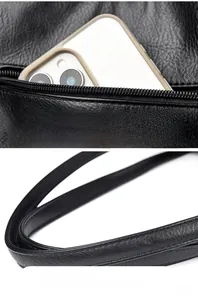 Detail of rear zipper pocket and soft leather handle on a black crossbody bag