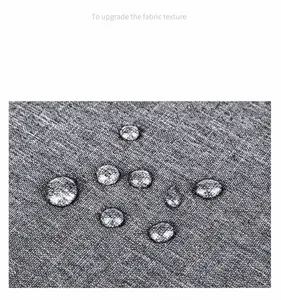 Primer plano de tela gris texturizada con capa impermeable y gotas de agua encima