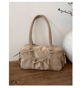 Détail du sac à bandoulière en daim beige avec nœud élégant et poche plissée chic