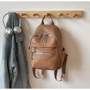 Detailed view of brown lychee texture backpack with silver double-ring zipper pulls