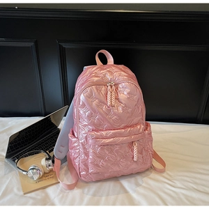 Close-up of pink quilted backpack with bow-shaped embossing and breathable mesh straps