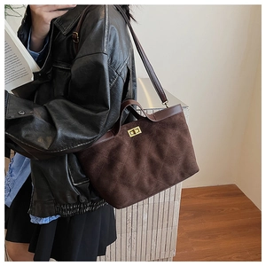 Détail du sac vintage marron foncé en suédine avec motif à losanges et fermoir doré