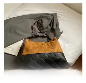 Detail of quilted two-tone shoulder bag with brown suede, black leather and chain strap