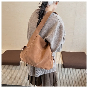 Détail du grand sac cabas en daim marron montrant la texture épaisse et la bandoulière