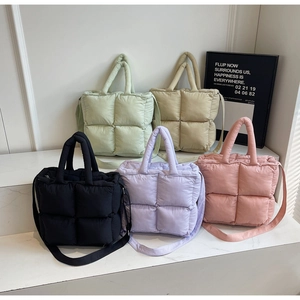 Detailed view of quilted puffer tote bags in black, purple, pink, green and cream colors