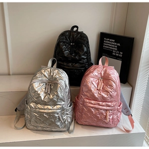 Detailed view of padded quilted backpacks with butterfly texture in silver, pink and black