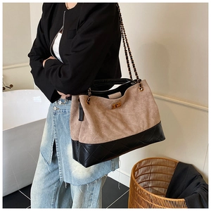 Close-up of beige suede and black quilted diamond pattern on large tote shoulder bag