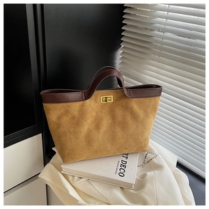 Détail du sac cabas en daim matelassé avec bordure en cuir marron et fermoir doré