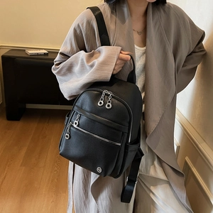 Minimalist black lychee leather backpack with silver zippers and multi-pocket design