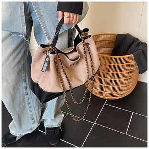 Detail of khaki suede tote bag with diamond quilting and leather chain strap
