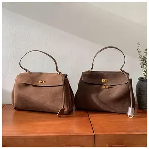 Detail of high-quality suede crossbody bags with vintage gold twist locks in two brown tones