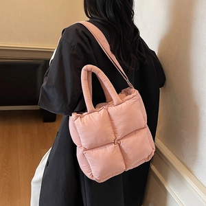 Pink quilted puffer tote bag with adjustable shoulder strap shown in a lifestyle view