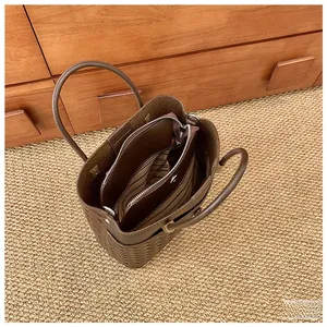 Top view of dark brown woven tote bag interior showing the spacious inner striped pouch