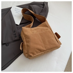 Détail du sac cabas marron en daim avec deux poches avant et compartiments à rabat latéraux
