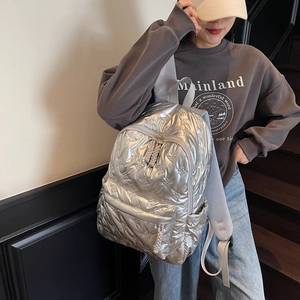 Silver quilted backpack with butterfly embossing and metallic finish on a female model