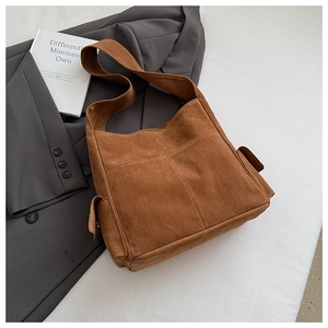 Détail du grand sac cabas en daim marron foncé avec poches latérales à rabat et coutures