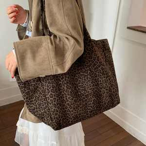 Large leopard print canvas tote bag shown with a model in a stylish autumn outfit