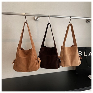 Trois sacs fourre-tout en daim marron montrant la texture mate et les poches latérales