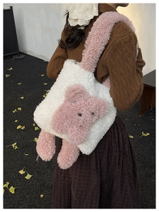 Détail d'un sac cabas en peluche crème avec un ours rose et une bandoulière douce