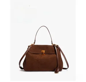 Detailed view of the dark brown matte leather handbag with elegant gold twist lock