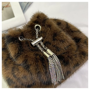 Detail of faux fur leopard print bag with silver chain and rhinestone tassel fringes