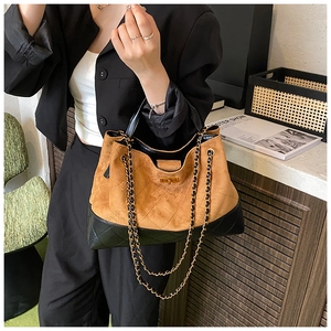Detail of suede and leather bucket bag featuring rhombus quilting and golden twist lock