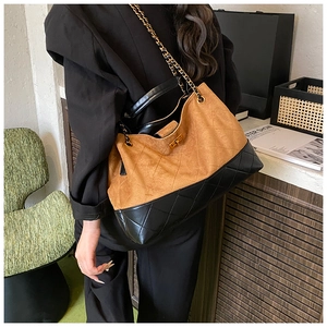Detail of suede and quilted leather bucket bag with gold lock and chain strap
