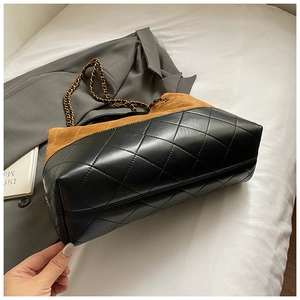 Detailed close-up of suede and quilted leather bucket bag with gold chain strap