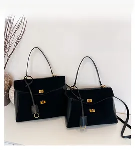 Détail de sacs cabas noirs mats en grandes et petites tailles avec boucles dorées élégantes