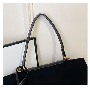 Vue détaillée du sac cabas noir avec anneaux dorés et fine bandoulière en cuir souple