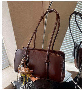 Détail du sac sous le bras en cuir rétro marron foncé avec pendentif ours en peluche
