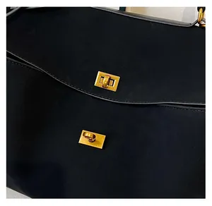 Détail du sac fourre-tout noir mat avec des fermoirs pivotants en métal doré vintage