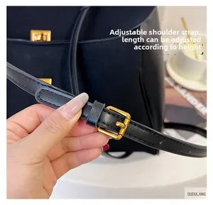 Détail de la bandoulière réglable en cuir avec boucle dorée sur un sac cabas noir
