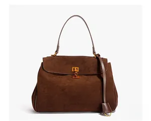 Detail of dark brown matte suede handbag with golden twist lock and top handle